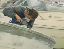 Marine technician inspecting sailboat deck equipment